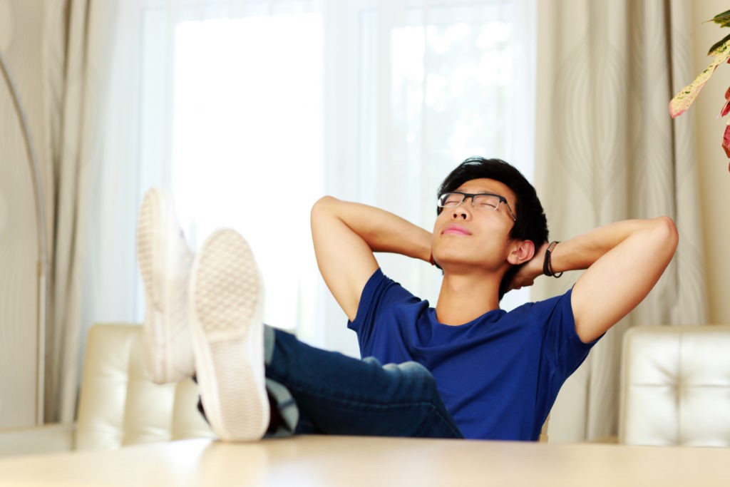 Asian man relaxing at home. He doesn't have to worry about the trouble to find tutors.