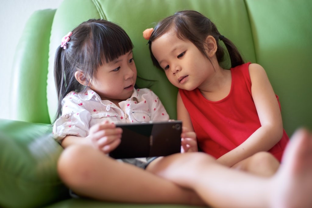 Two Asian girls playing with smart phone