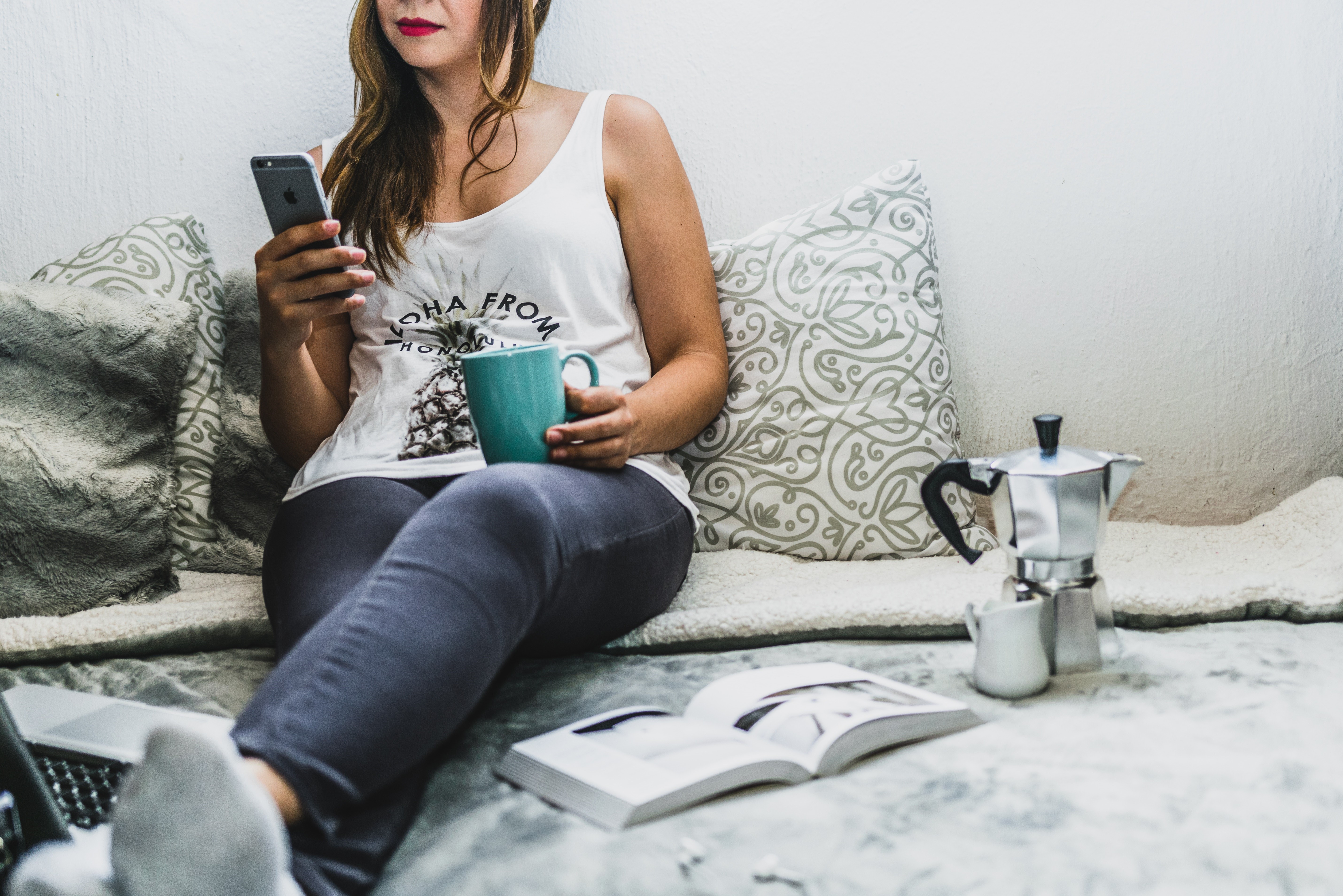 Freelancer lounging on bed using Tueetor on her mobile